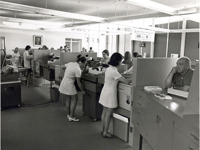 Women working at the counter of the Caisse populaire de Charlesbourg in the Québec region in the early 1970s